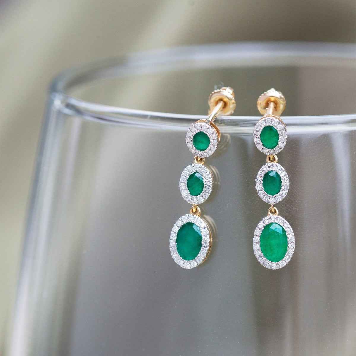 Oval Emerald and 1/3 ct. tw. Diamond Halo 3-Stone Drop Earrings in 14K Yellow Gold front view
