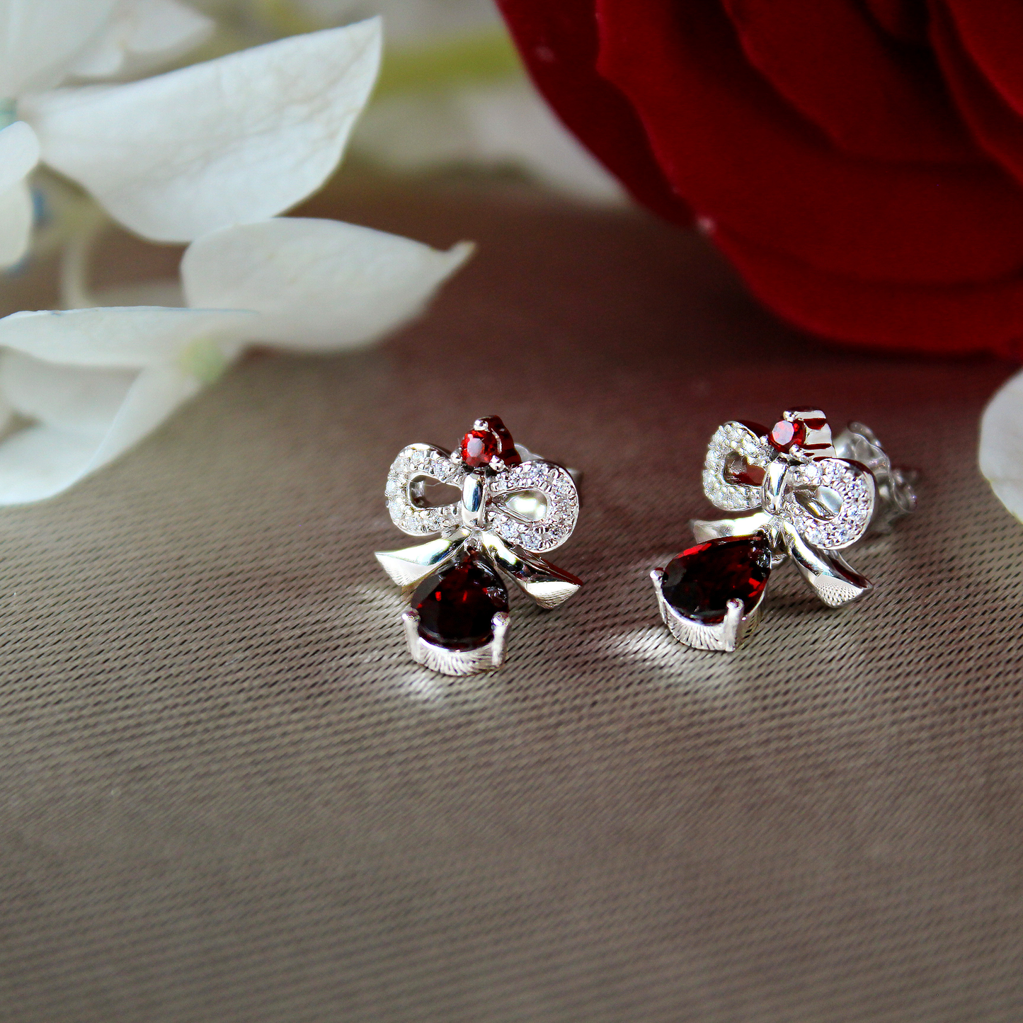 Enchanted Disney 1/10 ct. tw. Snow White Teardrop Garnet Bow Earrings in Sterling Silver front view