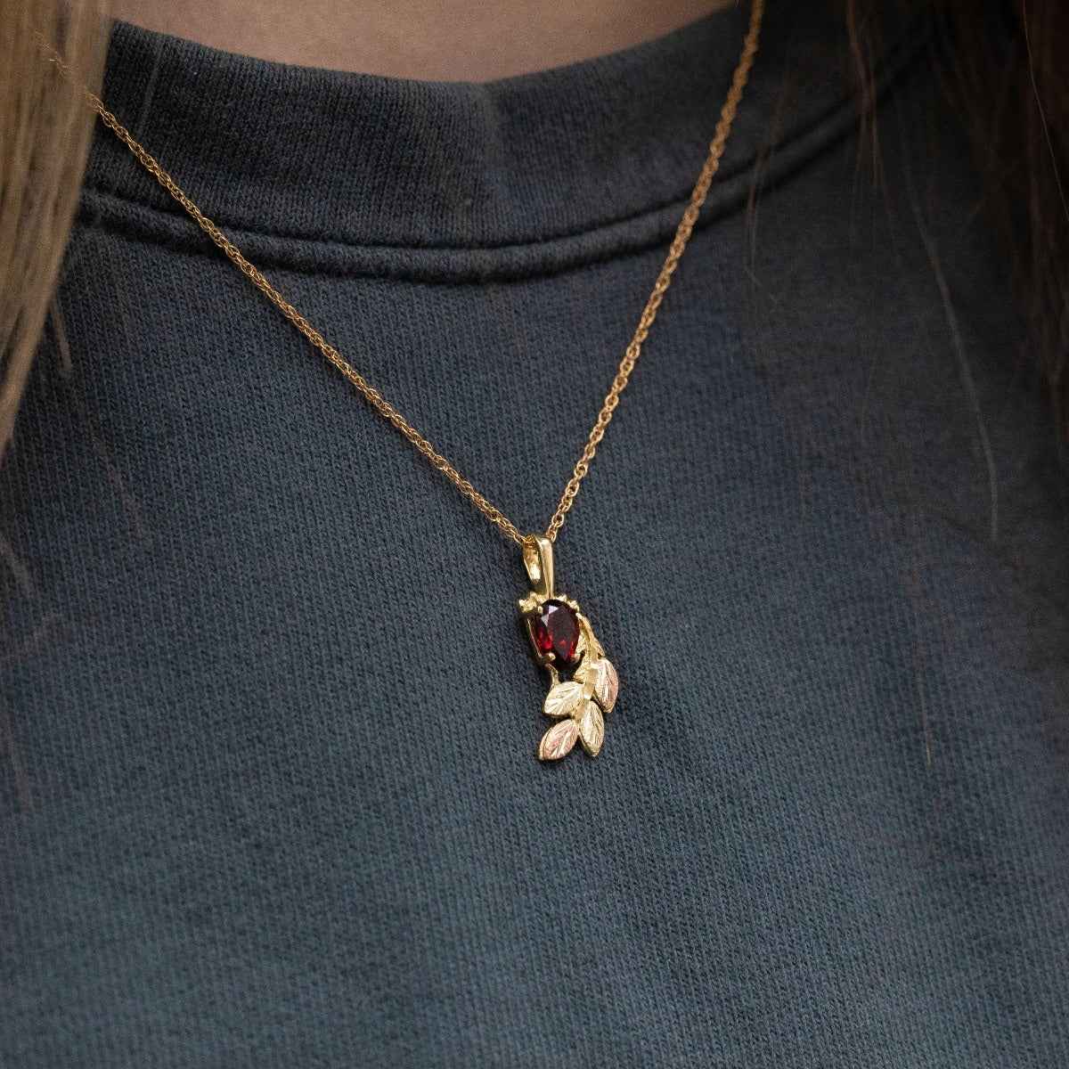 Black Hills Gold Pear Garnet & Leaf Branch Pendant in 10K Yellow Gold close-up detail
