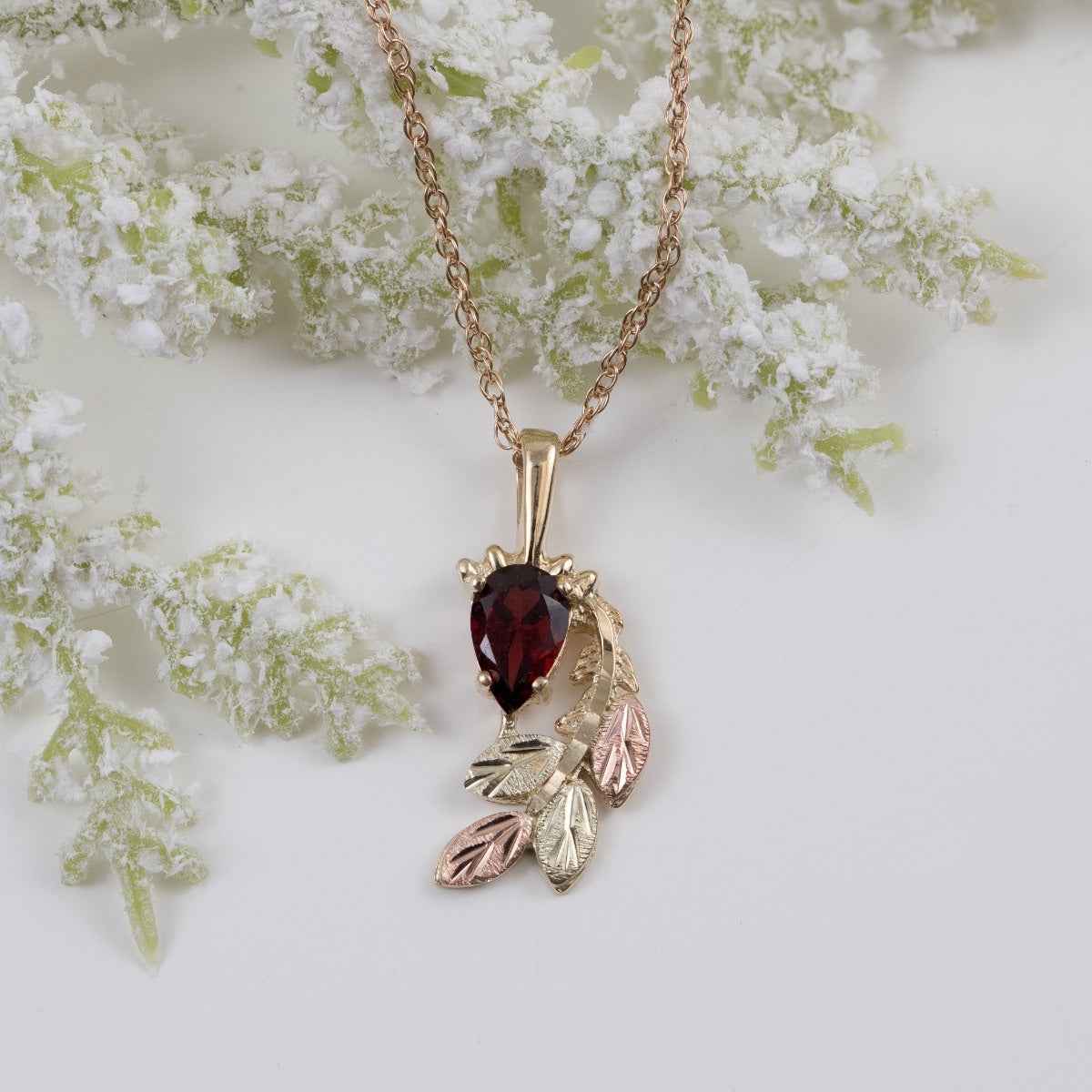 Black Hills Gold Pear Garnet & Leaf Branch Pendant in 10K Yellow Gold front view