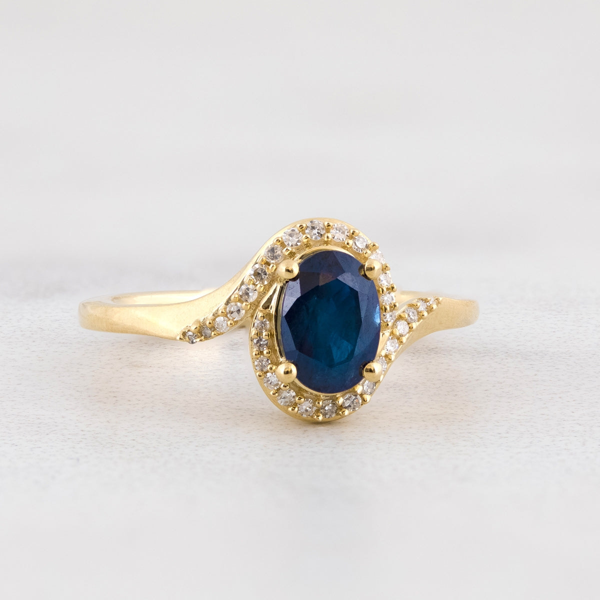Oval Sapphire & 1/10 ct. tw. Diamond Bypass Halo Ring in 10K Yellow Gold close-up detail