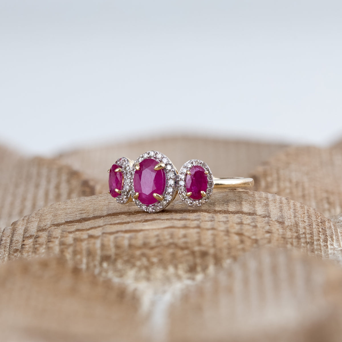 3-Stone Oval Ruby & 1/5 ct. tw. Diamond Halo Ring in 14K Yellow Gold close-up detail