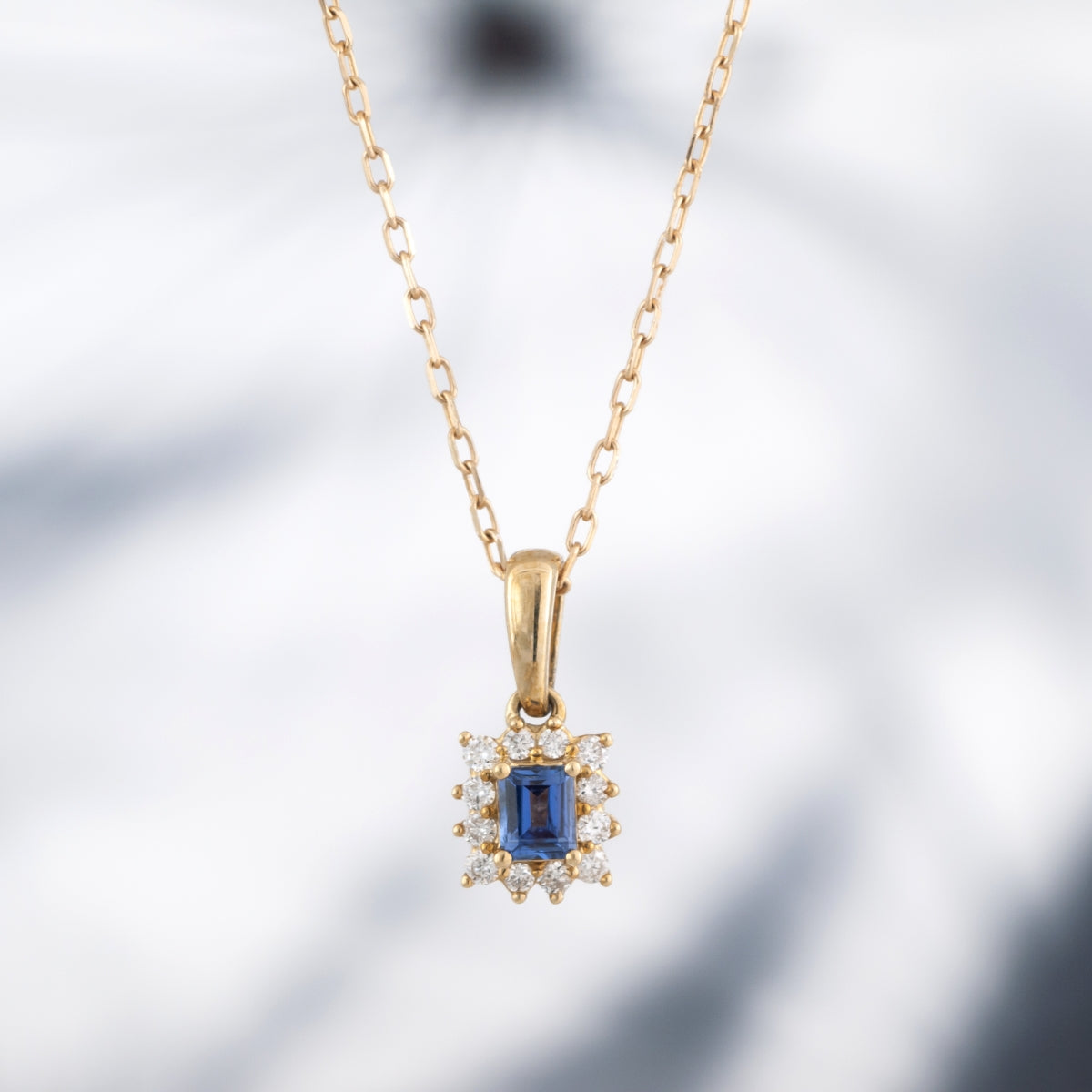 Baguette Yogo Sapphire & 1/10 ct. tw. Diamond Halo Pendant in 10K Yellow Gold front view