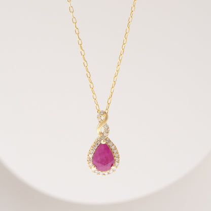 Infinite Love Pear Ruby & 1/10 ct. tw. Diamond Halo Twist Pendant in 10K Yellow Gold front view