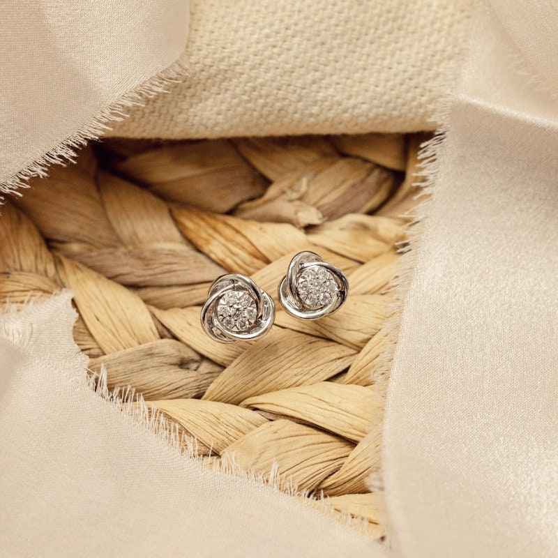Love Knot 1/6 ct. tw. Diamond Cluster Earrings in 10K White Gold front view