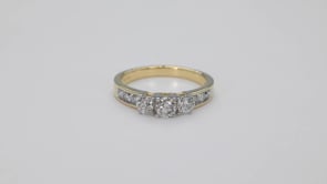 1 ct. tw. 3-Stone Round Brilliant Diamond Anniversary Ring with Channel Set Side Diamonds in 10K Yellow Gold close-up detail