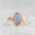 oval opal and diamond halo pink gold ring beauty shot